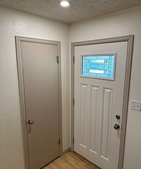 Front entrance exterior door and entry coat closet.