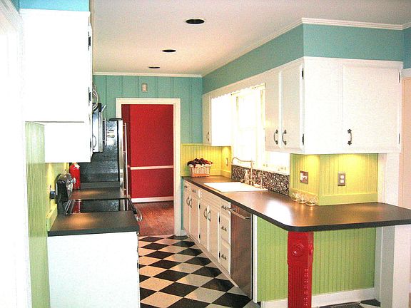 Kitchen with bright colors. under cabinet lighting, and bar/eating area.