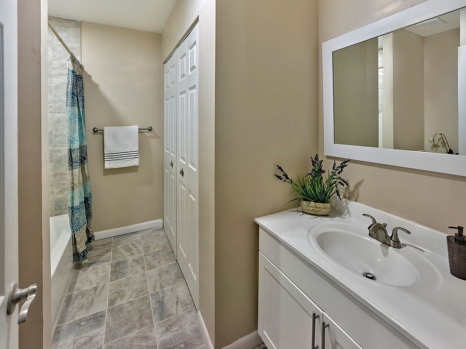 Stylish and updated bathroom at Haynes Run Apartments featuring sleek tile flooring, a spacious vanity, and neutral tones.