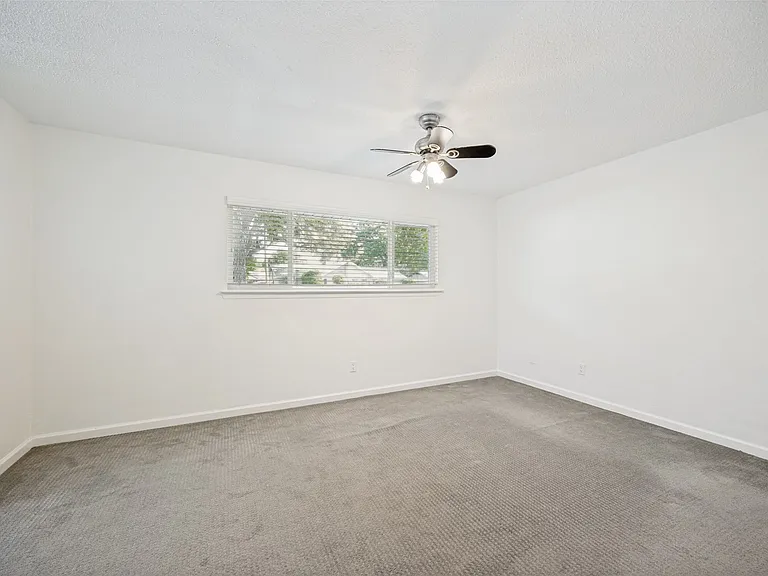 Spacious room featuring neutral carpeting and white walls
