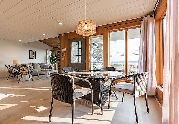 to your right is a dining room with abundant natural light and floor ceiling windows to look out to the garden and the ocean