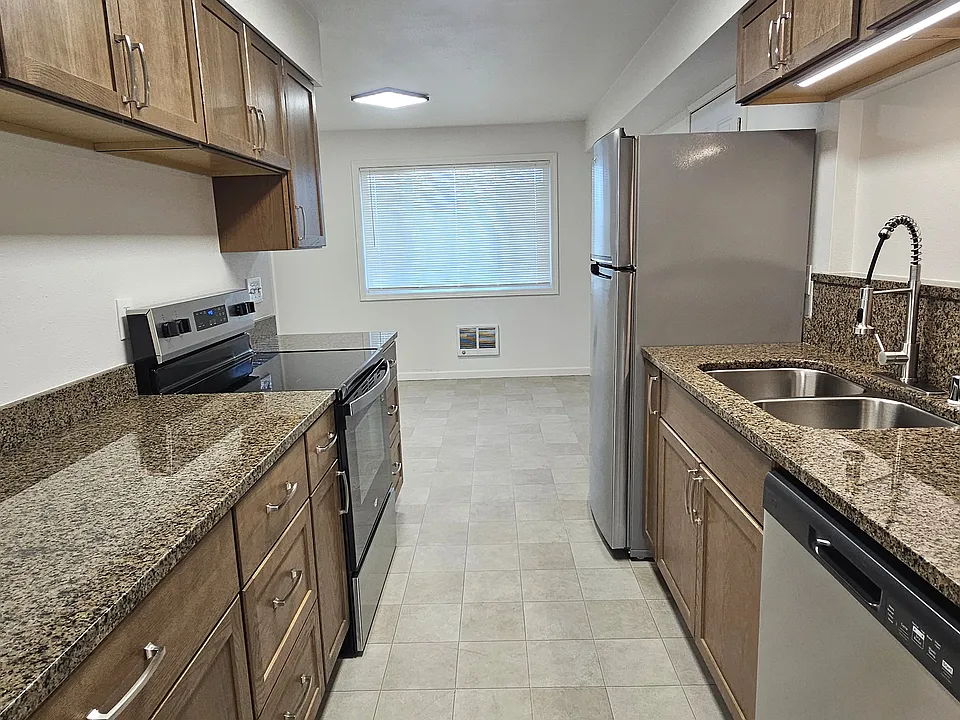 The style of this contemporary is timeless. Beyond the beautiful look, check out all that counter and cabinet space. The full size refrigerator and stove/oven will be great for cooking family or gourmet meals. The room is bright with natural light.