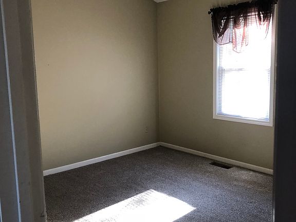 Upstairsw bedroom with window facing front yard. Full closet