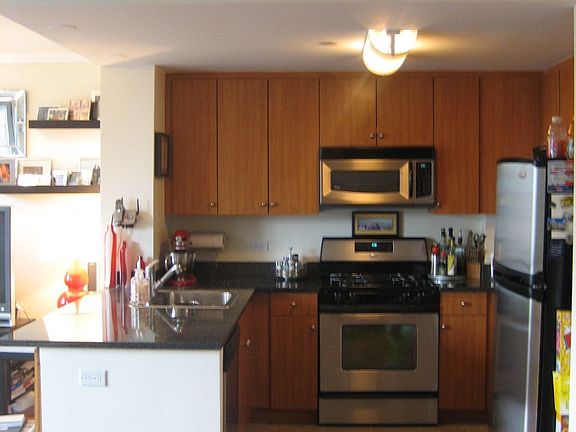 Open floorplan kitchen with granite countertops, GE stainless steel appliances