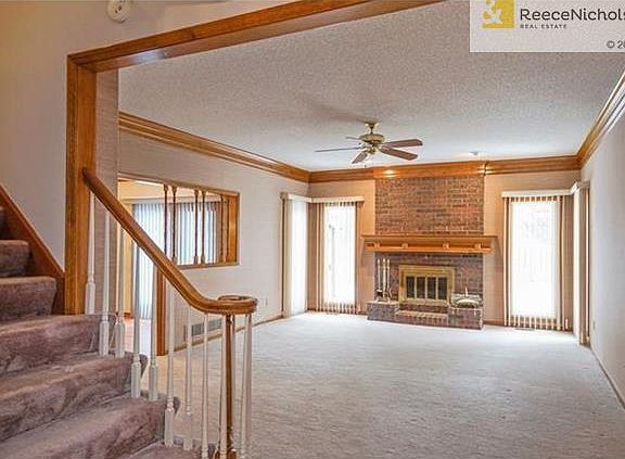 Entry opens to the large open great room with brick fireplace and beautiful woodwork