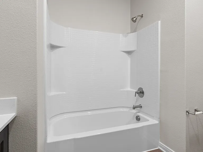 The secondary bathroom has a vanity and shower-tub combo.