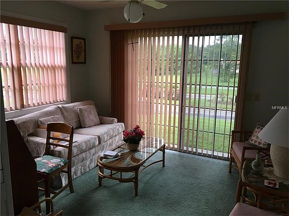 Florida room showing sliding glass doors onto patio slab, ceiling light & fan. Doors & windows with 