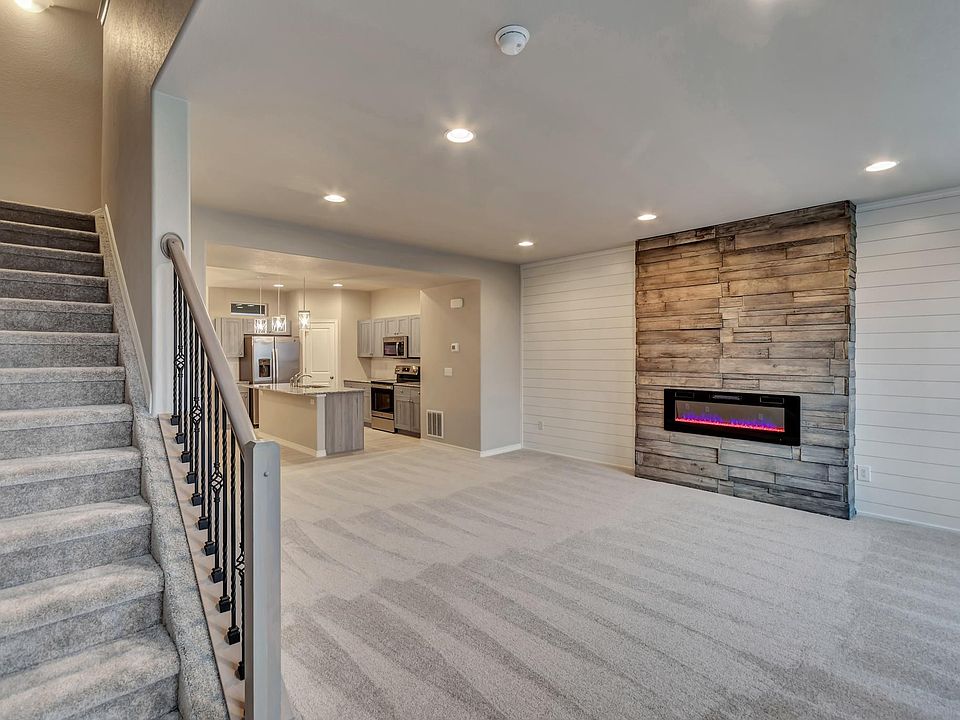 Custom stone fireplace wall with heat producing, color changing electric fireplace adorned with ship lap craftsmanship on both sides.