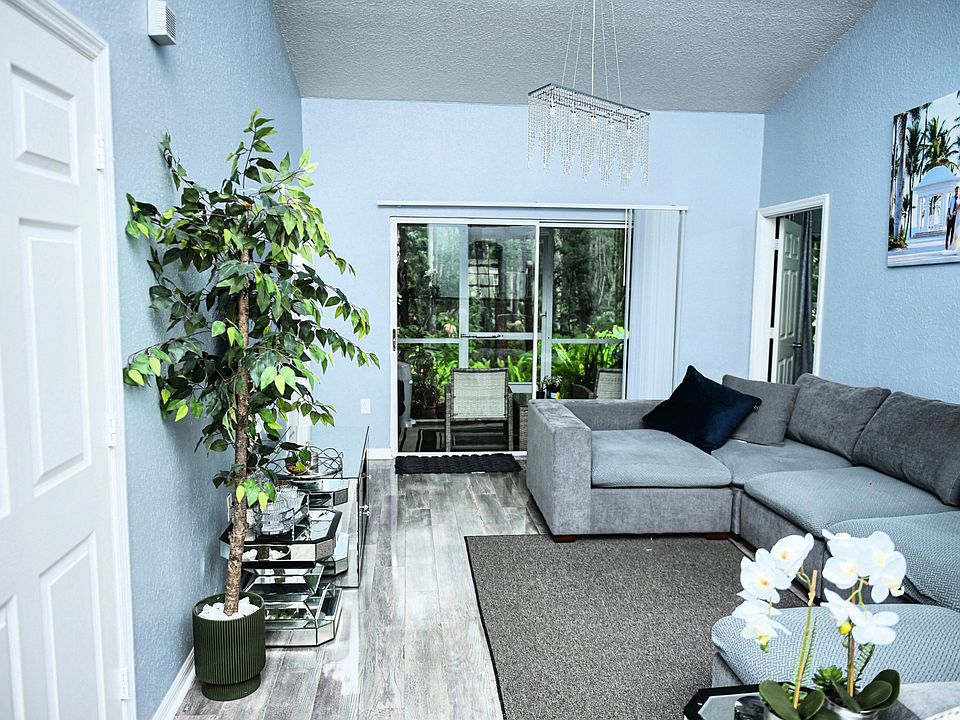 Living Room _ Inviting living room with high ceilings, sleek floors, and access to nature-view lanai