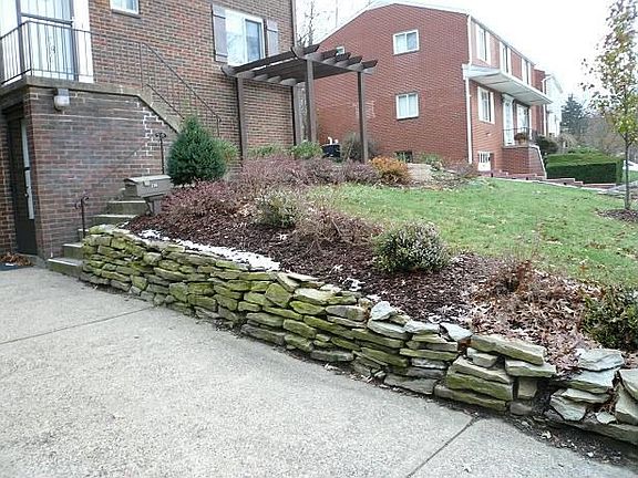 The driveway is framed by beautiful dry-stacked stone walls.