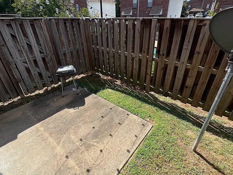 Fenced in patio area with gate to pool