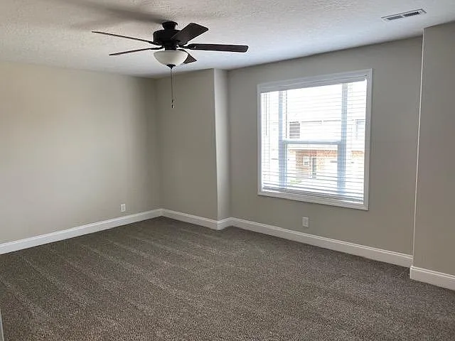 master bedroom with fan and walk in closet