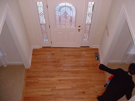 Front Entry view from upstairs - leaded glass window and oak hardwood flooring