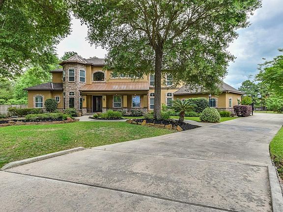 Large driveway leading to the four car garage and wrought iron driveway gate, leads to Custom Home built by Emerson homes with 7 bedrooms, 5 full and 2 half bathrooms.