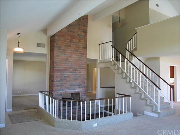 Living room conversation area with fireplace looking to fami
