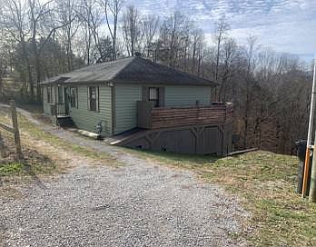 The driveways runs parallel to the house and is at a slight incline. Three normal sized vehicles can park in a row in front of the home.