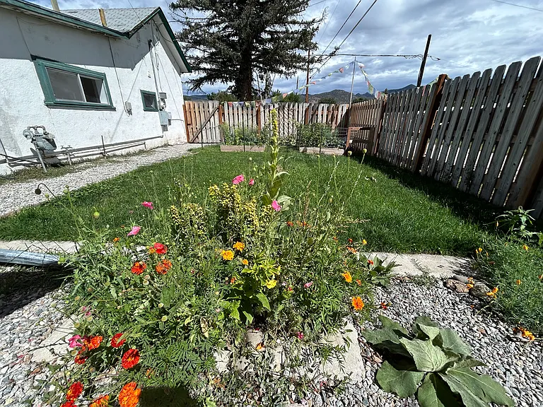 Planter perfection! This charming spot overlooks the lawn and raised garden beds, making it the ideal perch for your favorite flowers_or judging your veggies' progress with a cup of coffee in hand.