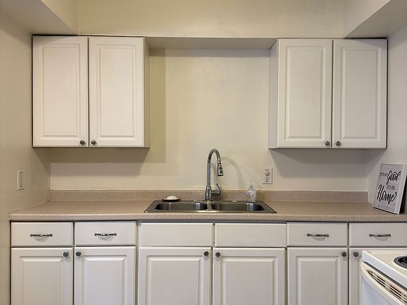 Pretty, white cabinets with ample cabinet storage space and a double sink.