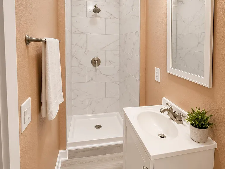Updated bathroom with a tiled walk-in shower, single-sink vanity, and overhead lighting for daily convenience.