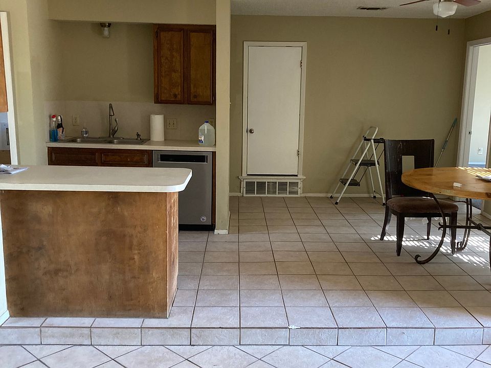 Kitchen & Dining Area: Open kitchen with bar seating and adjoining dining space featuring ceiling fan and tile flooring.