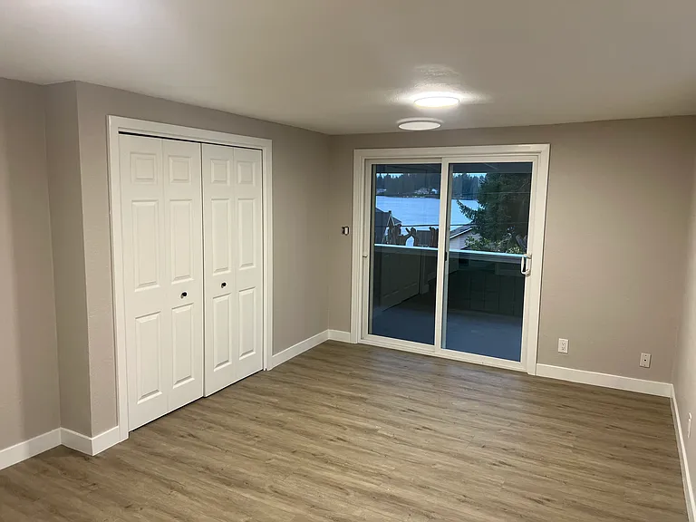 Bedroom on main level looking out to spacious deck and view of Martha Lake