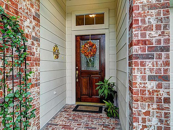 Brick-layed entry with custom stained wood door with lead glass.