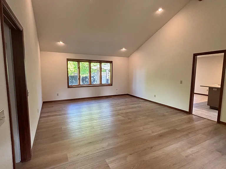 Open living and dining room with vaulted ceiling and brand new floors
