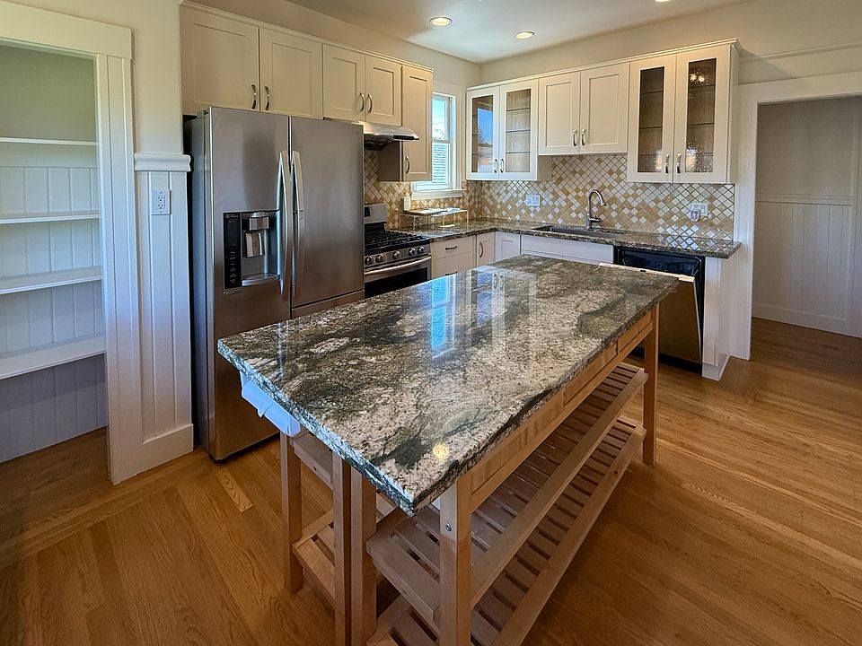 Kitchen features granite countertops, large island, updated appliances