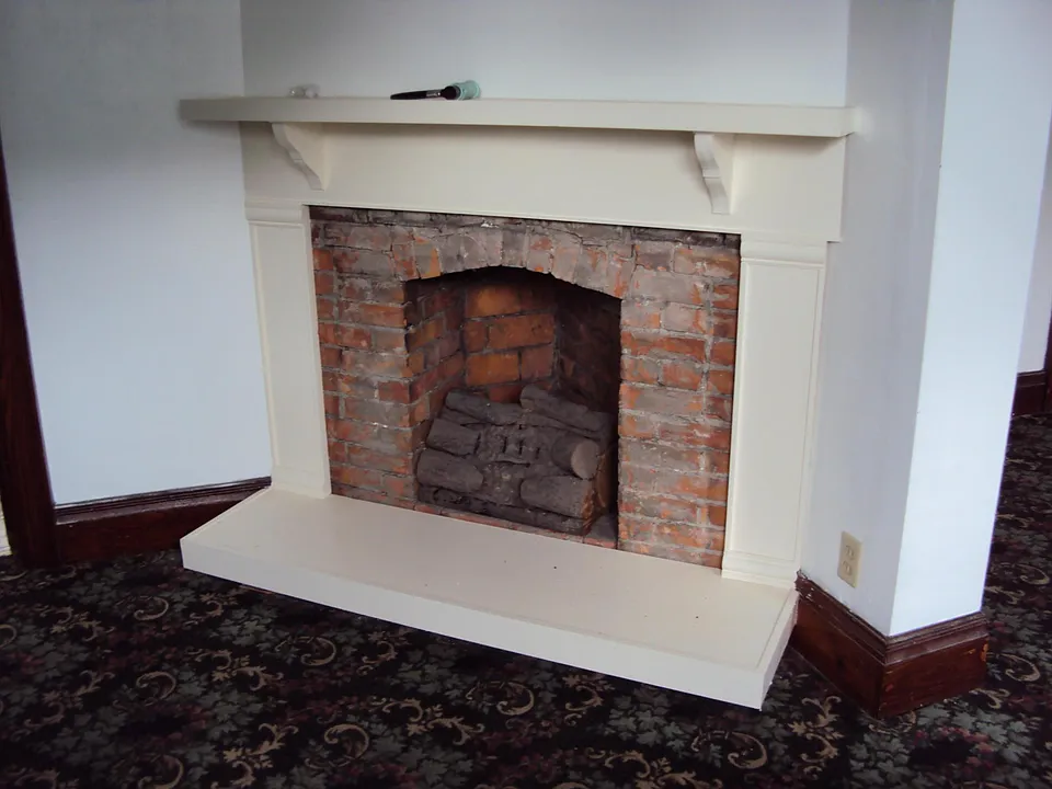decorative brick/wooden fireplace with large mantle
(carpet has been removed) now hardwood floor