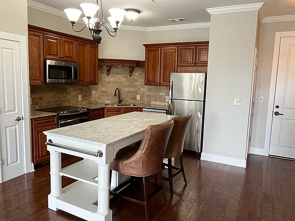 Upscale kitchen features granite countertops, custom cabinetry, stainless steel appliances, a spacious marble island and two pantries. Renters may use the Pottery Barn counter chairs, if desired.