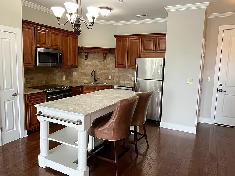 Upscale kitchen features granite countertops, custom cabinetry, stainless steel appliances, a spacious marble island and two pantries. Renters may use the Pottery Barn counter chairs, if desired.