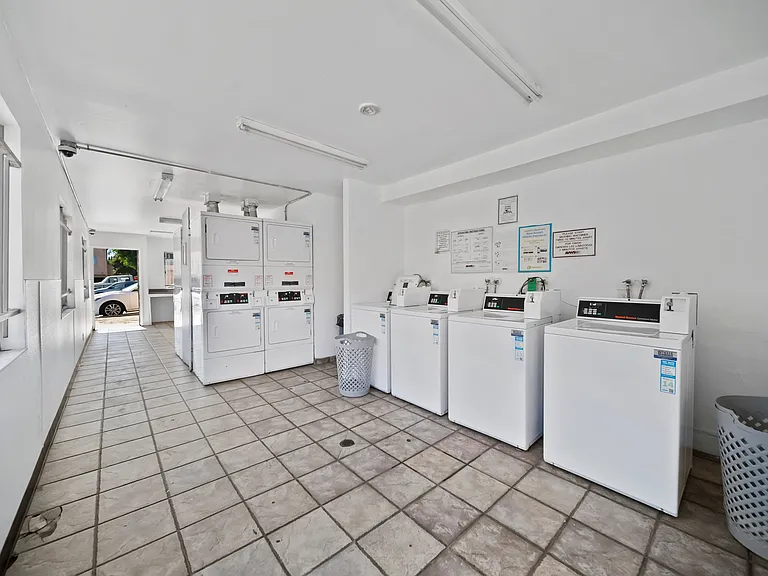 Spacious on-site laundry room with multiple washers and dryers for resident convenience.