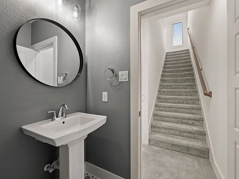 Functional and elegant powder bathroom off main living area and view of stairs to the third floor.