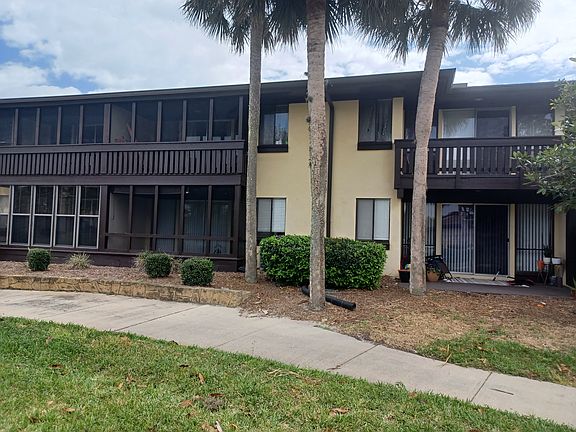 View from rear of buiding. Shows wrap patio around living room area. Also shows the screened in porch off master bedroom to the left. Center view is the guest bedroom.
