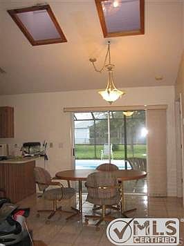 Dining room has slider to lanai, cathedral ceiling and 2 sky