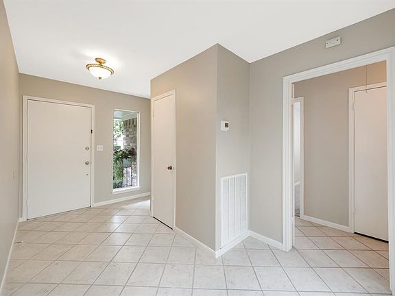 Light, bright foyer way leads directly to an open atrium. Hallway on left leads bedrooms and baths.