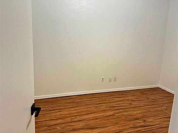 Unfurnished room featuring wood finished floors and a textured ceiling