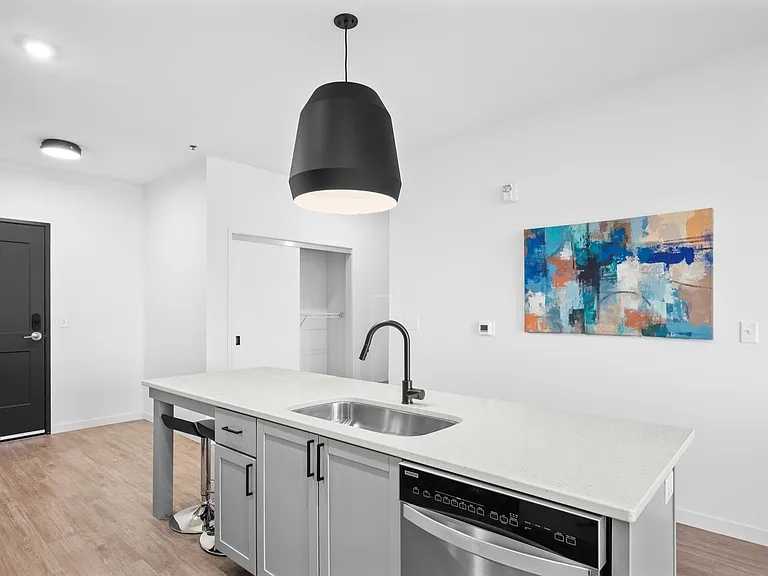Modern kitchen with sleek island, contemporary lighting, abstract art, and stylish bar seating. Modern kitchen with sleek island, contemporary lighting, abstract art, and stylish bar seating.