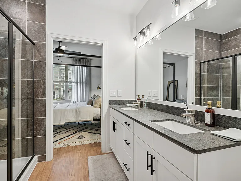 Bathroom with Granite Countertops, Double Vanity Sinks, Walk-in Shower, and Walk-in Closet
