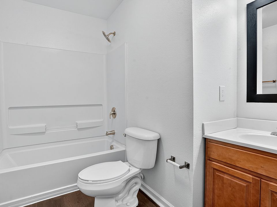 Bright and modern bathroom featuring a sleek bathtub, elegant fixtures, and a stylish vanity with a large mirror.