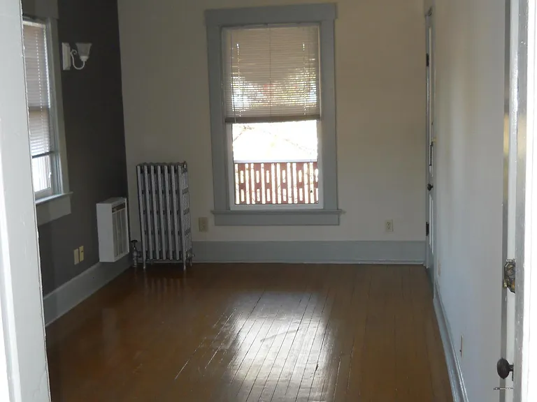Living Room North Window looks out to Large, roofed 2nd floor front porch. 3 smaller West-faced windows allows plenty of Natural light. All windows have mini-blinds window treatments in Unit #2.