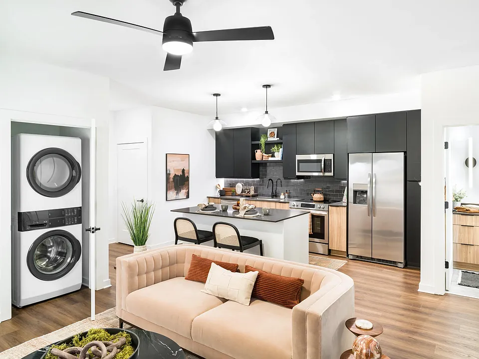 An open living area at Modera Nations in Nashville features wide-plank flooring, an island kitchen, and in-home laundry for seamless everyday living.