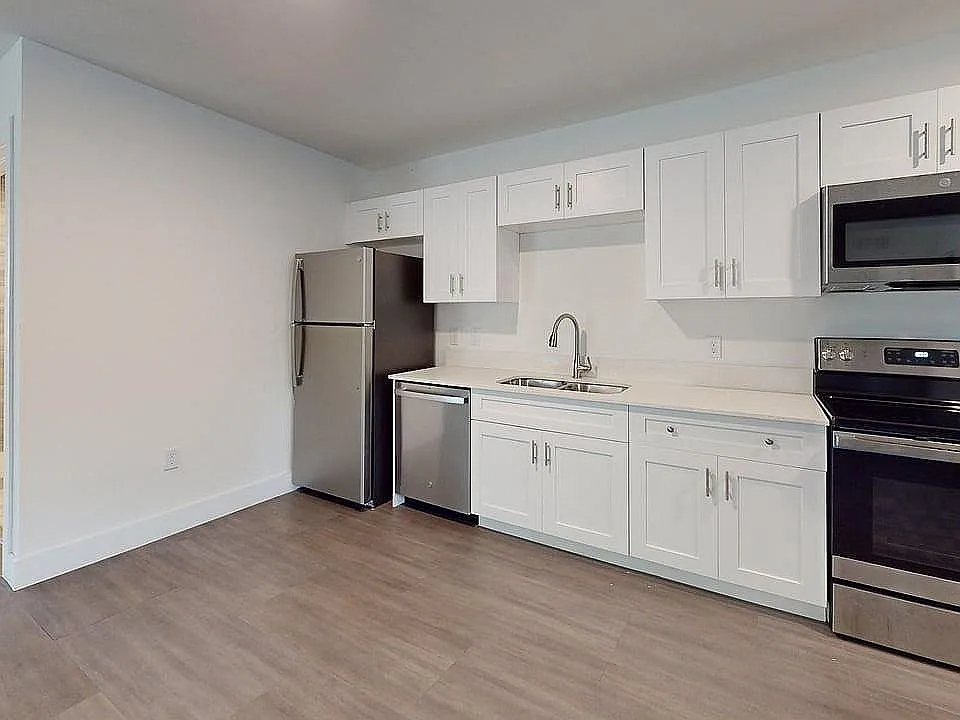 Modern kitchen with sleek stainless steel appliances, elegant white cabinetry, and polished countertops, offering a contemporary and functional space.