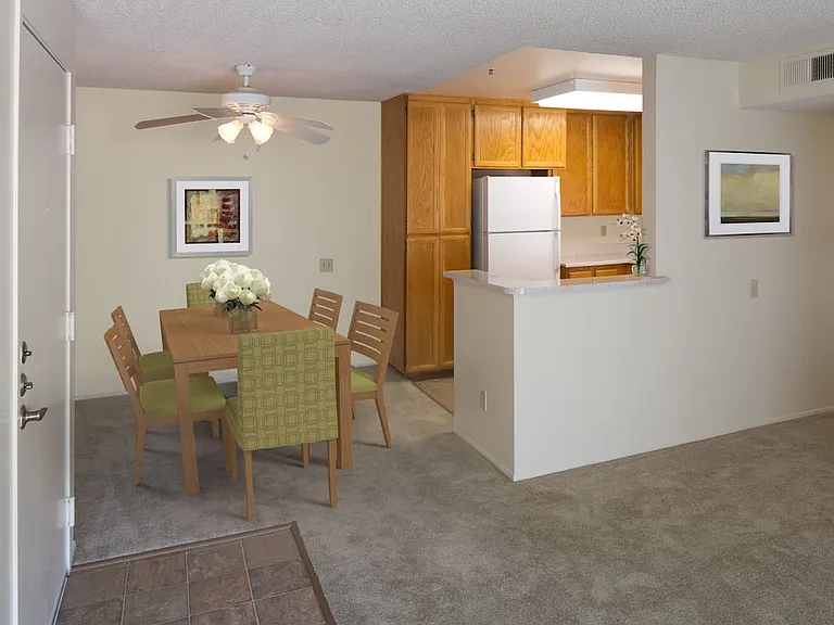 Classic Package kitchen with oak cabinetry, beige speckled laminate countertops, tile flooring, and white appliances