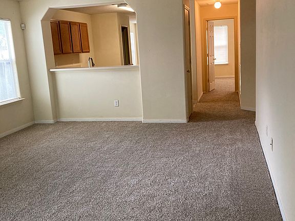 Living room and views of hallway and kitchen from entrance