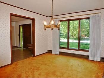 A formal dining room boasts large picture windows.