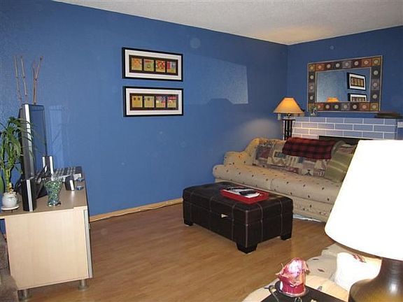 Spacious living rm w/ newer laminate wood floors, brick accented fireplace