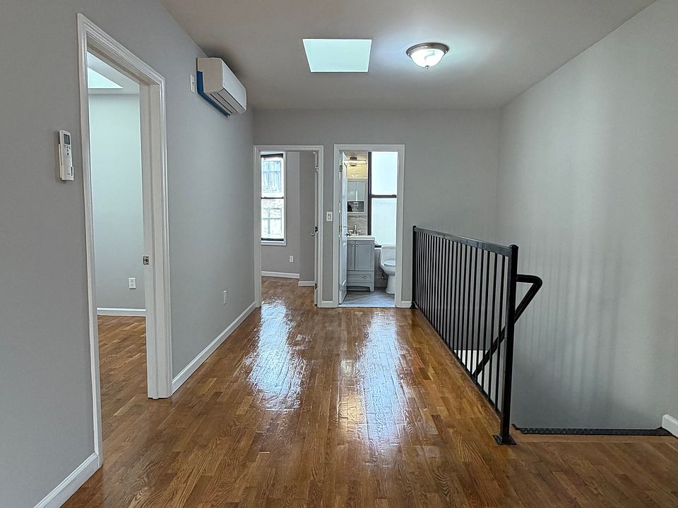 living room area with skylight and hardwood floor throughout