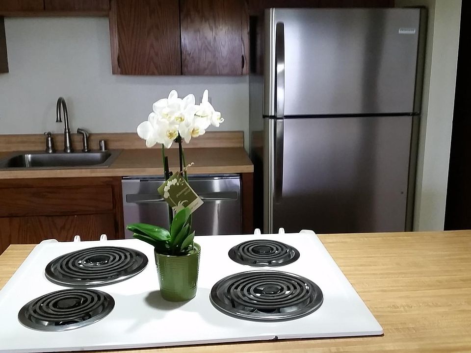 Kitchen Island stove with sink and refrigerator in the background