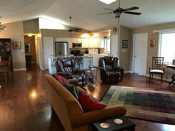 Living area with lounge and recliners, kitchen in the back